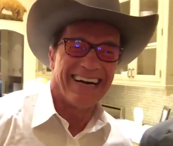 Person wearing a cowboy hat and glasses in an indoor setting